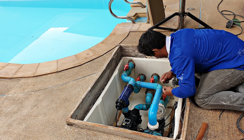 Technician fixing swimming pool water pump. Service and maintenance for swimming pool.