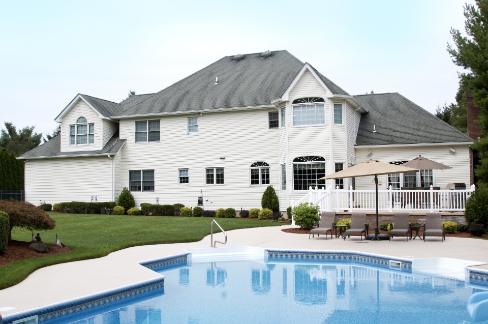 White house with inground pool in the backyard